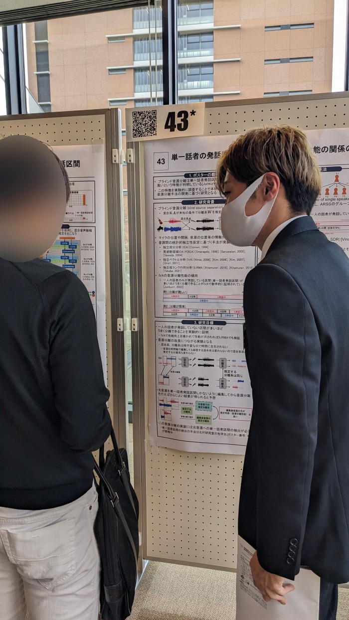 ポスター発表中の鈴木君の写真